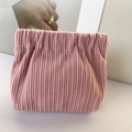 Detailed close-up of pink corduroy lipstick pouch with a flexible spring squeeze closure - No Label Plain / Pink