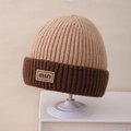 Dettaglio del berretto in maglia con cuciture a contrasto e toppa min sul bordo piegato - Solo Cappello / Cachi