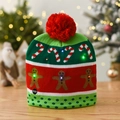 Close-up of festive LED knit hat featuring gingerbread man patterns and a power switch - Red Green Gingerbread Man
