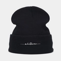 Close-up of whatever letter embroidery on black knitted beanie with ribbed texture - One Size / Black