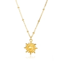 Detailed view of a golden sun pendant necklace with radiated rays and beaded chain - Beaded Chain Sun Disc
