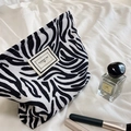 Retro zebra print corduroy makeup bag with label on soft white fabric background - Zebra Print