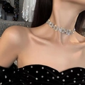 Nahaufnahme der silbernen Tropfen-Halskette mit glänzenden Kristallen an einem Model - Silberne Quadratische Strass Mode-Choker