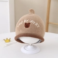 Detail der Baby-Strickmütze mit Lucky Baby-Stickerei und einem süßen Bären-Patch - 1-4 Jahre / Khaki