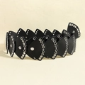 Detail of black leather fan-shaped belt with metal eyelet studs on a beige background - Black / 105cm