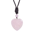 Dettaglio macro del ciondolo a cuore in quarzo rosa con trama liscia e cordino nero intrecciato - Quarzo rosa