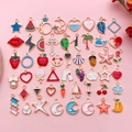 DIY colorful enamel jewelry charms in heart and star shapes on a pink background - Set of 51 Mixed Charms (1 Each)