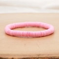 Roze bohemien polymeerklei Heishi armband met elastisch koord op houten ondergrond - Roze