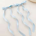 Detailed view of light blue ribbon bow hair clips with long wavy streamers on silk fabric - Blue (1 Pair)