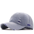 Close-up of distressed light blue denim baseball cap with 1999 side embroidery - Navy Blue