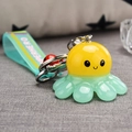 Gros plan d'un porte-clés poulpe avec sangle bleu sarcelle et petit pendentif coccinelle - Jaune