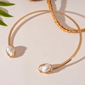 Detail van een gouden metalen halsketting met twee barokke parels in een C-vormig ontwerp - Gouden Parel Metalen Choker
