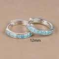 Macro detail of 12mm silver hoop earrings with channel-set blue zircon stones - 12mm / Silver (Blue Zirconia)