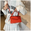 Detail of orange crocodile pattern PU leather handbag with twisted handle and gold hardware - Orange