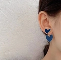 Navy blue heart drop earrings with gold plating on a model for a stylish look - Blue