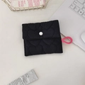 Black heart-quilted sanitary bag with white snap button and pink lanyard on desk - Heart Quilted Black Square Sanitary Bag