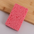 Rosa Holzstoff-Schwamm mit Wabenstruktur auf Holzoberfläche für die Küchenreinigung - Rosa