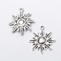 Macro shot of two vintage silver sun-shaped alloy pendants for DIY jewelry making crafts - Antique Silver