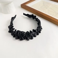 Close-up of black pleated wave-shaped fabric headband with soft texture on a clean background - Black