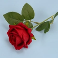 Single red velvet artificial rose with green leaves on a light blue background - Bright Red