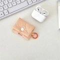 Dettaglio ravvicinato di una custodia protettiva trapuntata color pesca per AirPods - Arancione