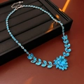 Vista dettagliata della collana a fiori con cristalli blu su un espositore per gioielli - Collana / Blu
