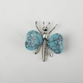 Silver-toned butterfly ornament featuring heart-shaped turquoise stone wings and detail - Turquoise