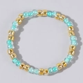 Beaded ring featuring gold accent beads and translucent aqua blue stones in a stackable style - Lake Blue and Gold