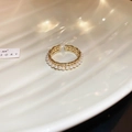 Close-up of golden adjustable ring with micro-pearl inlay on elegant wave plate - Vintage Woven Pearl Open Ring / Gold