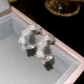 Close-up of silver-plated flower hoop earrings with sparkling zircon crystals - Silver
