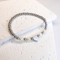 Detalle de pulsera elástica de cuentas plateadas con perlas y colgante de corazón - Corazón / Color Acero