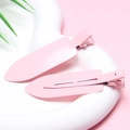Close-up of two pink metal creaseless hair clips on a white heart-shaped ceramic tray - Pink - Glossy without Letters