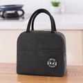 Detail of black insulated lunch bag featuring reinforced handles and front pocket - Black
