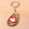 Détail macro du porte-clés en bois en forme de goutte avec motif festif du Père Noël - Père Noël