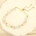 Detailed shot of an adjustable baroque pearl bracelet with colorful stone chips on a tray - White Moonstone