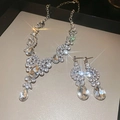 Nahaufnahme von Tropfen-Strass-Halskette und Ohrringen im Silber-Set mit Glanz-Effekt - Zweiteiliges Set (Silber) / Silber