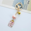 Vista dettagliata del portachiavi Maneki Neko in ceramica con ciondolo rosa e campanellino - Gatto della fortuna rosa