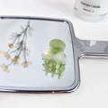 Mini light green marble acetate hair claw clip reflected on a mirror with candle - Jelly Green