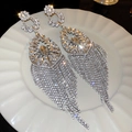 Close-up of sparkling silver tassel earrings with crystal rhinestones on a white plate - Silver Long Tassel Drop Earrings (HE17014)