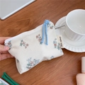 Close-up of a floral cotton coin purse with blue strap on a wooden desk setting - Vintage Small Flower on White Background
