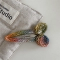Macro shot of rainbow crochet hair clip with metal logo charm on canvas background - Waterdrop Clip