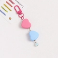 Close-up of pink and blue heart-shaped pendants with metallic chain for keychain decor - Pink and Blue Hearts