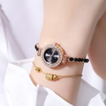 Close-up of gold gemstone watch and beaded bracelet set worn on a female wrist - Black
