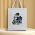 White canvas Christmas tote bag featuring a snowman couple print on a display stand - Style 1