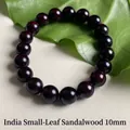 Pterocarpus santalinus 10mm red sandalwood bead bracelet displayed on a green leaf - 10mm*19 Beads High Density Old Material