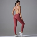 Macro detail of cross-back straps and scrunch butt design on red fitness bodysuit - Wine Red