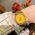 Detail of gold steel watch with yellow dial and date window on a female wrist - Gold Case Yellow Dial