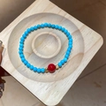 Détail macro du bracelet en perles de turquoise avec agate rouge et accents dorés - Style Turquoise Synthétique