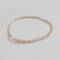 Macro view of handmade stretch bracelet with faceted amethyst and golden metal beads - Pink Opal