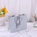 Elegant matte grey gift paper bag with satin bow and woven handles on marble surface - 28*20*10cm / Silver Grey + Matching Ribbon